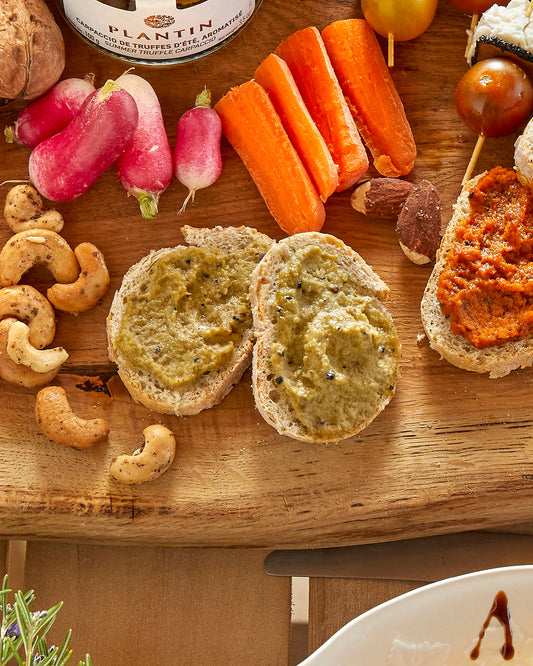 Truffle artichoke spread on toasted bread, served with radishes, carrots, cashews and other dips