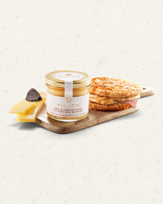 Jar of Comté and truffle cream on a wooden board with a wedge of Comté, a truffle and toasted bread