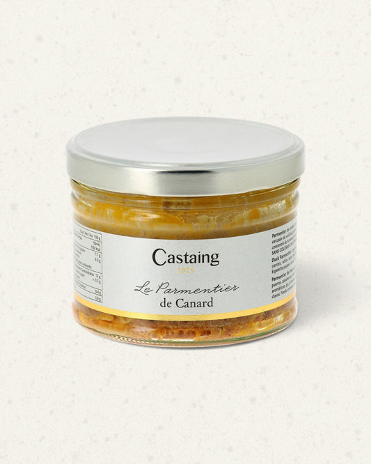 Wide glass jar of Castaing duck parmentier with a silver lid and a white label, golden layers visible
