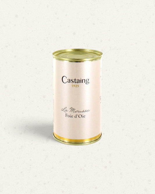Tall cream and gold tin of Castaing goose liver mousse with Castaing branding, on a light background
