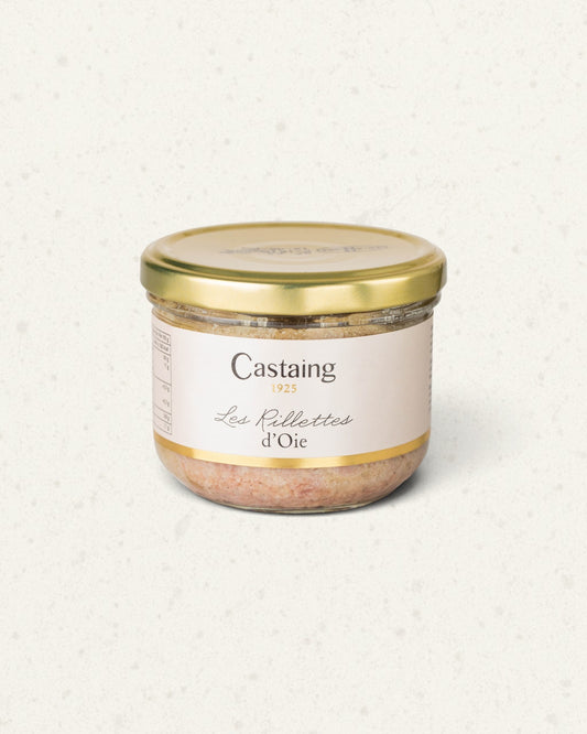 Wide glass jar of Castaing goose rillettes with a gold lid and a white label, on a light background