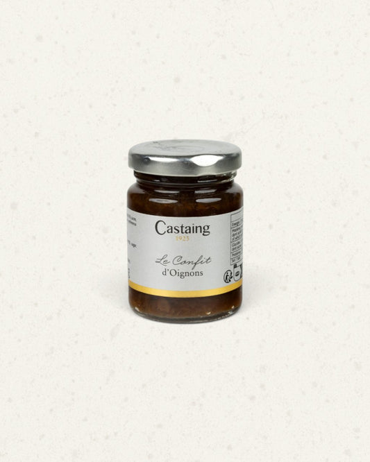 Small glass jar of Castaing onion confit with a silver lid and a white label, dark confit inside