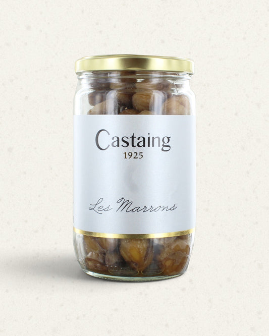Tall glass jar of Castaing cooked chestnuts with a gold lid and a white label, whole chestnuts inside