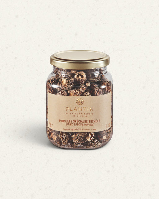 Clear jar of Plantin dried morels with a gold lid and a beige label, filled with whole dark morels