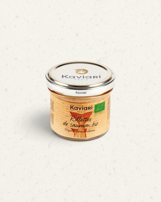 Small glass jar of Kaviari organic salmon rillettes with a silver lid and an orange fish drawing on the label